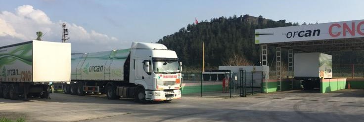 Wide shot of Orcan CNG facility with multiple green trailers and trucks at industrial site
